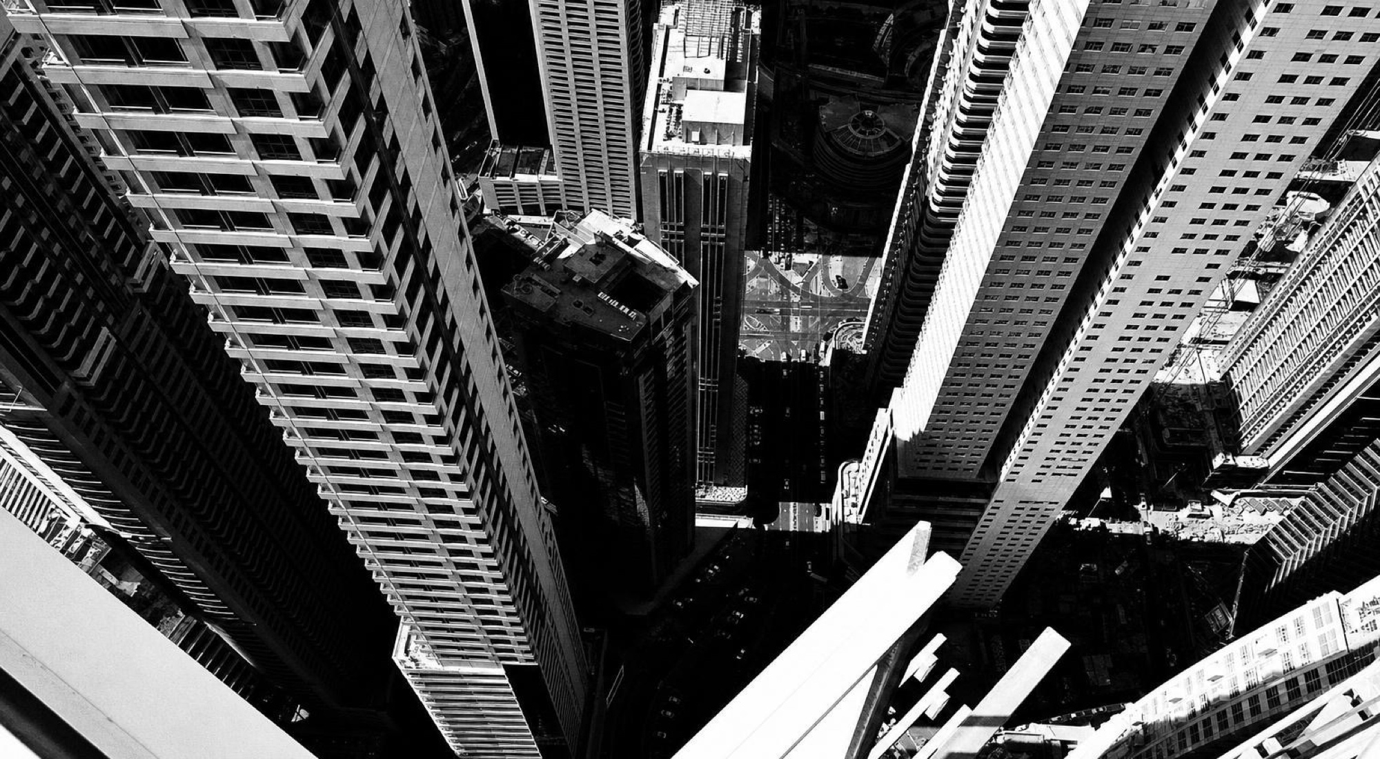 Looking straight down between high-rise towers to the street below