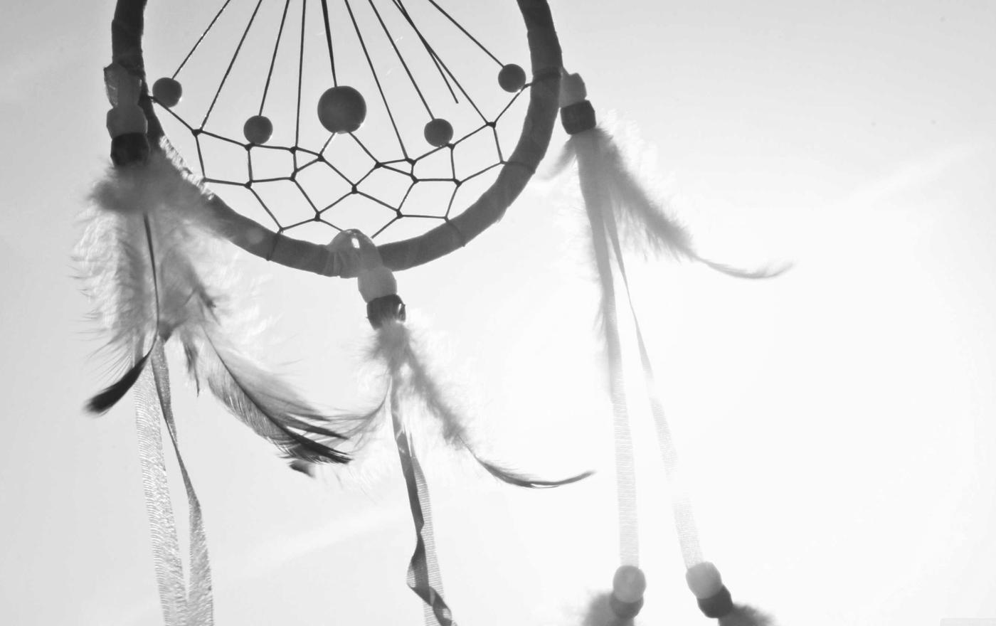 A dreamcatcher against a bright sky