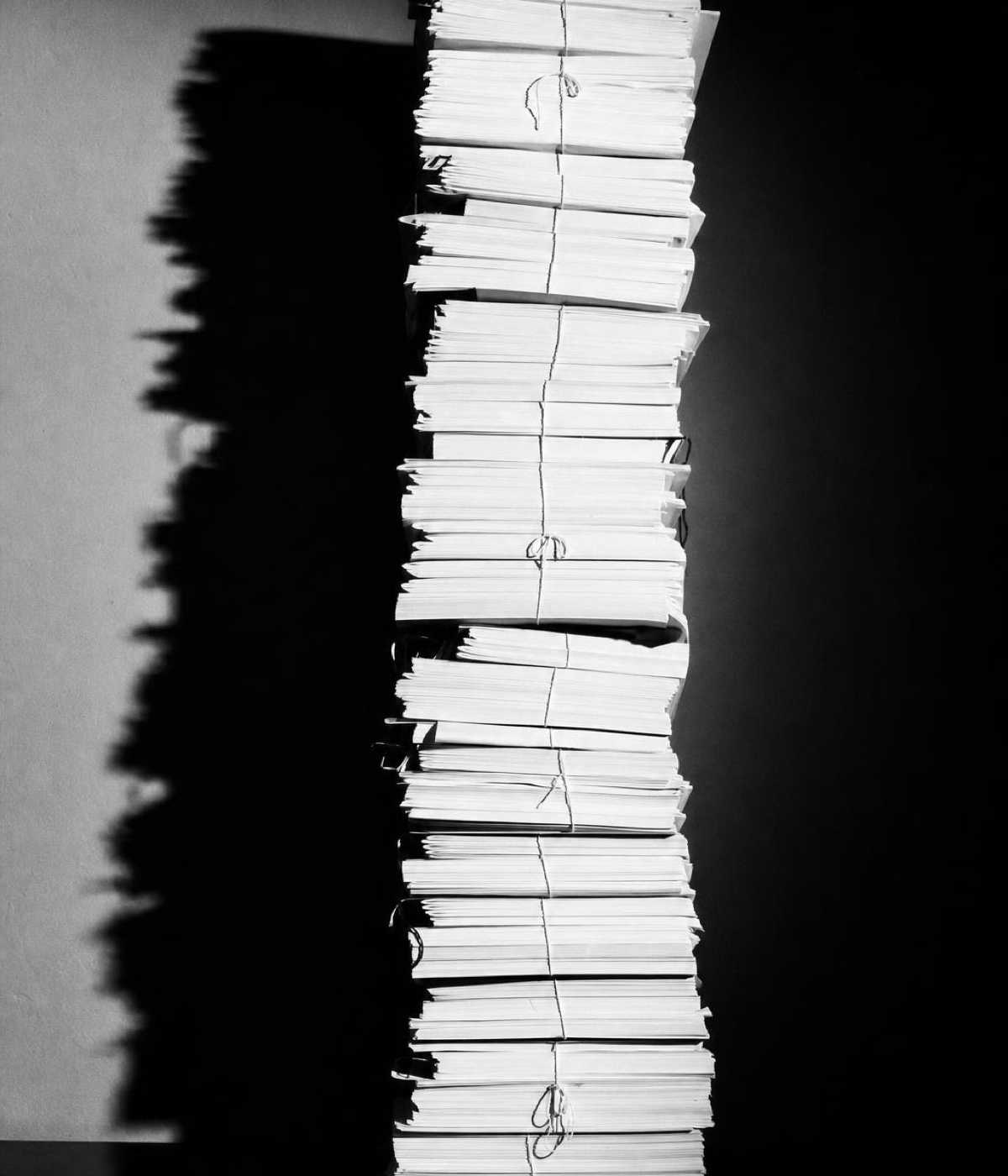 A fanned stack of documents in silhouette