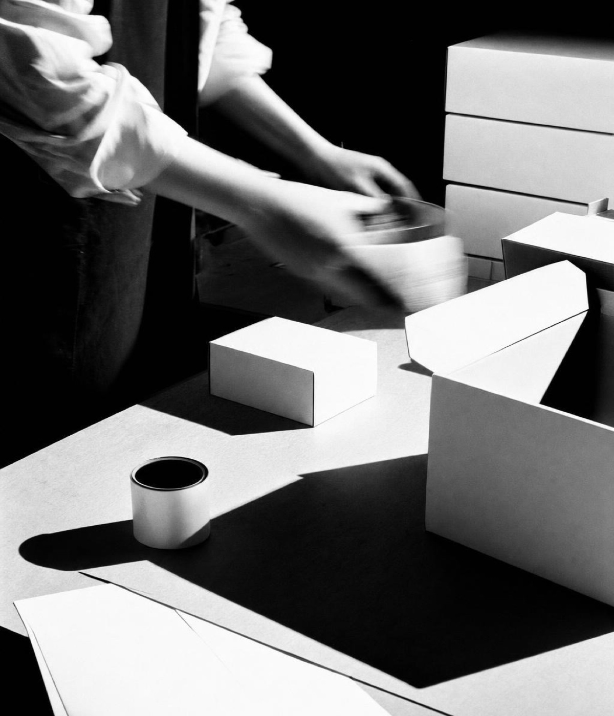Hands over stacked boxes and a cup of coffee