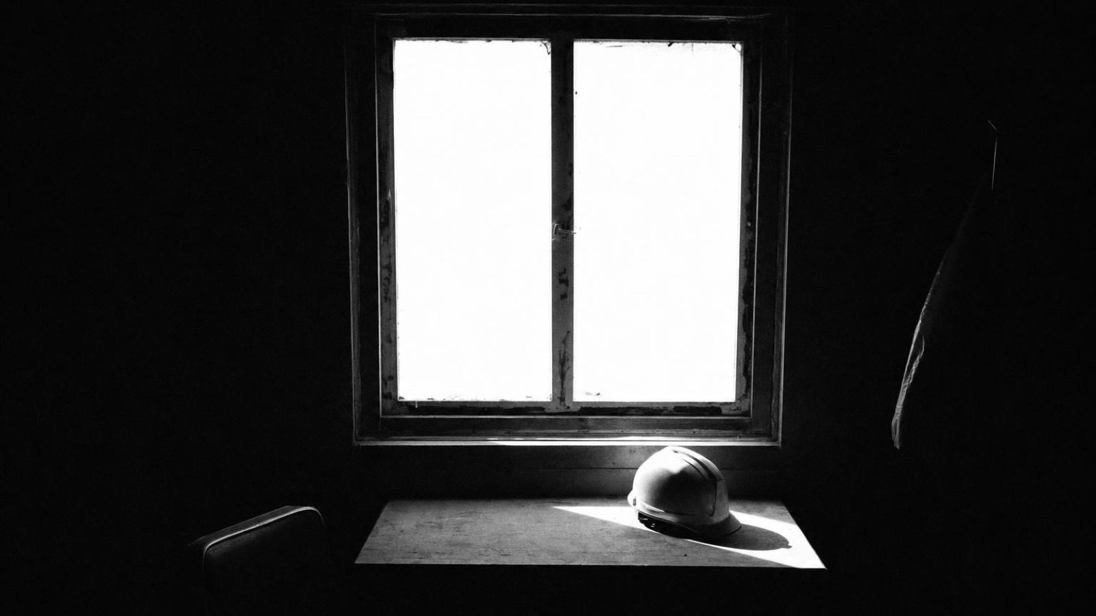A hard hat left on a windowsill in daylight