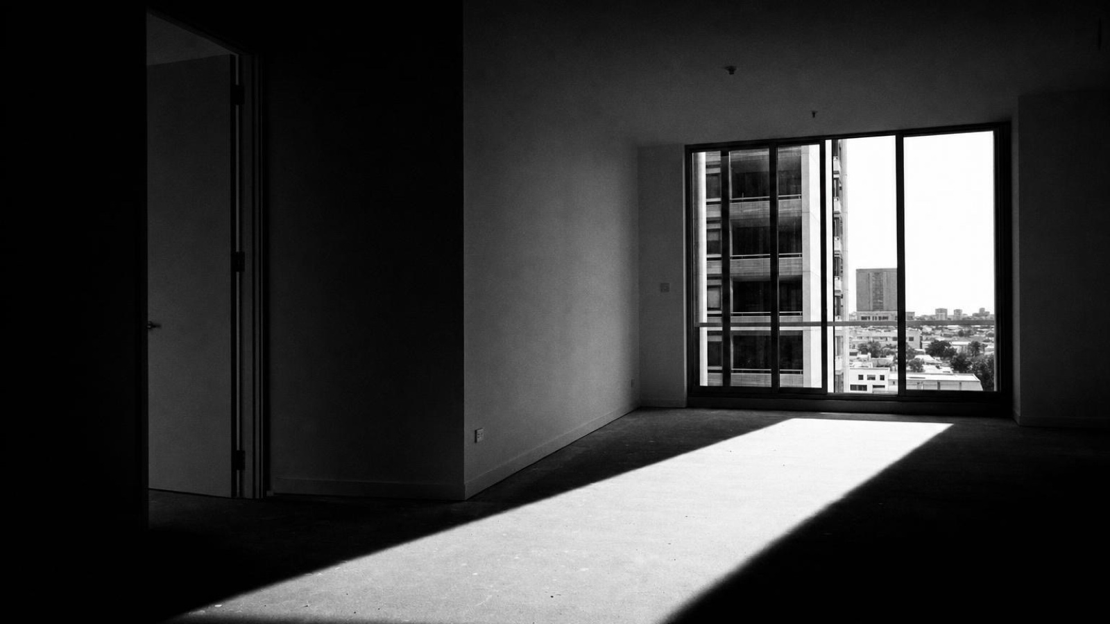 An empty room with a window onto the city